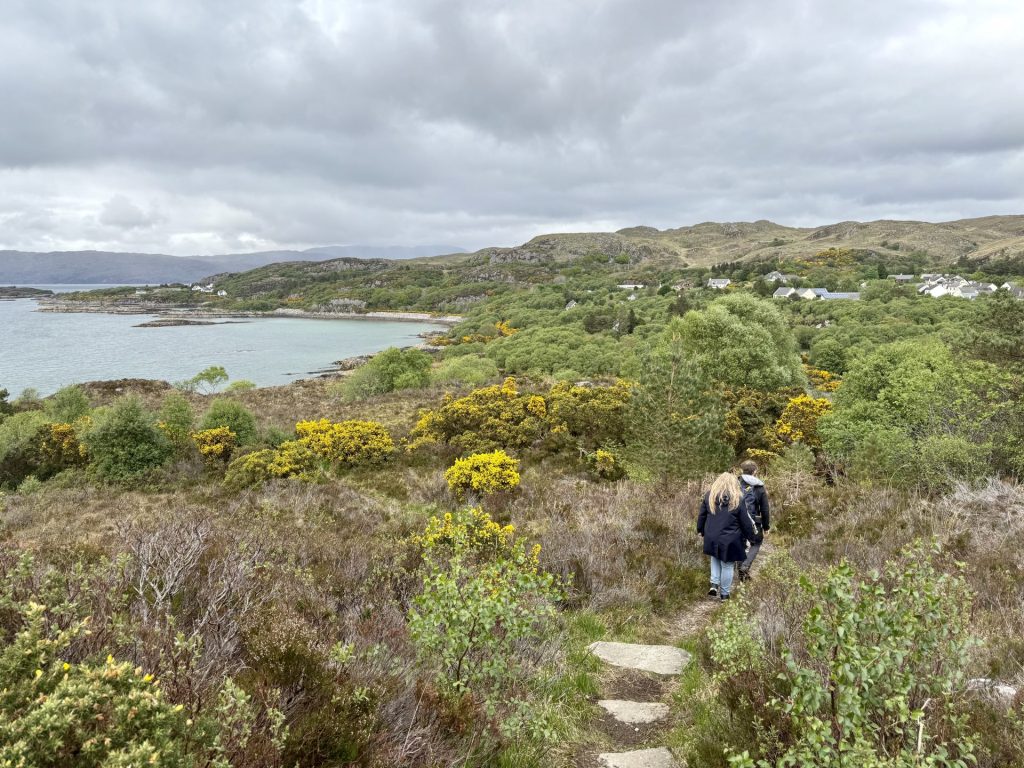 Mennesker der går på en sti i et naturområde med en bugt